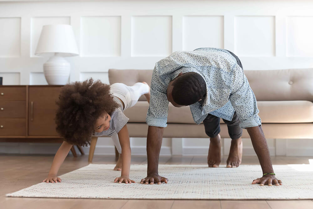 father and daughter doing yoga at home