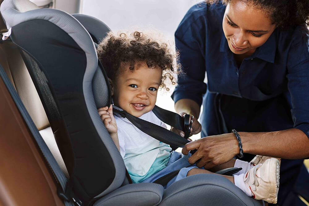mother securing child in a car