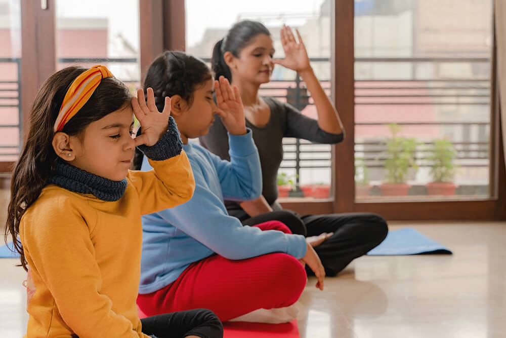 daughters and mom doing yoga meditation at home